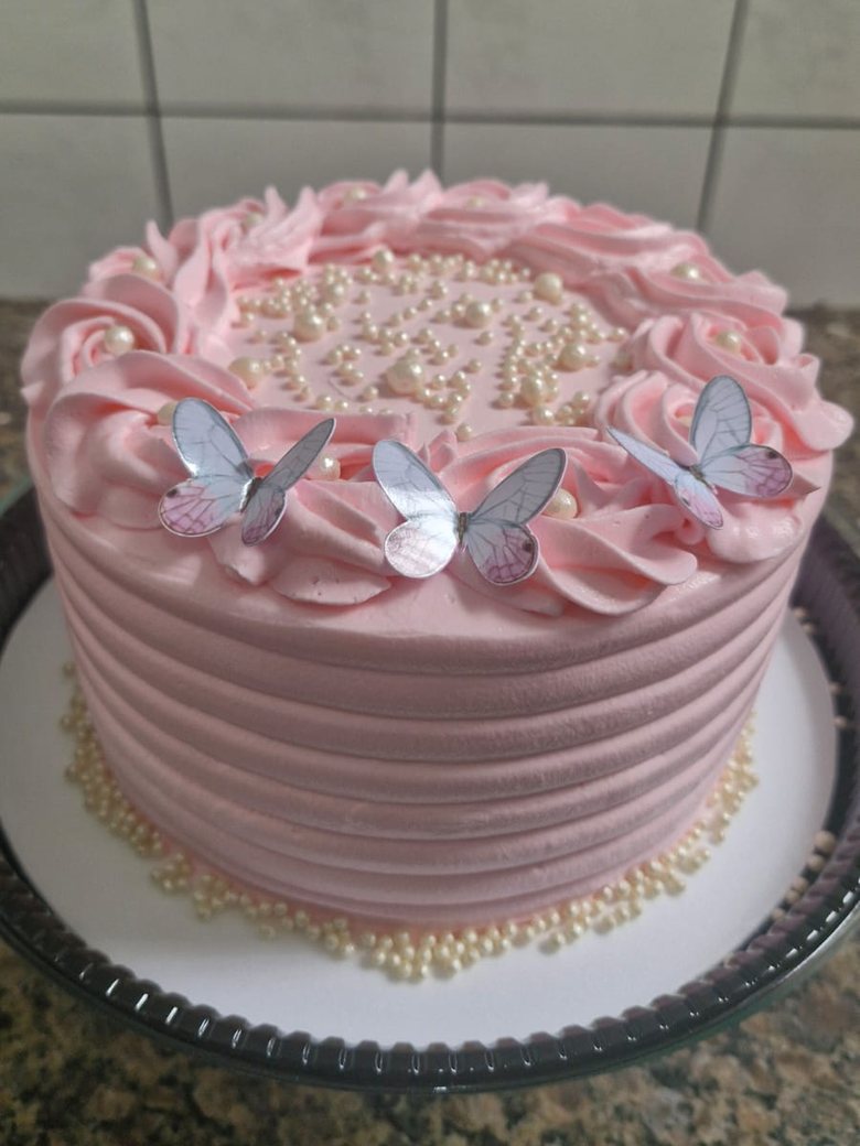 Bolo rosa decorado com rosas de chantininho, pérolas e borboletas